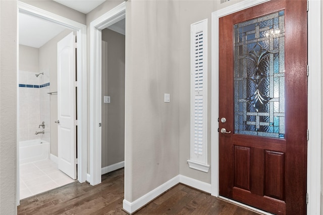 foyer featuring baseboards and dark wood-type flooring