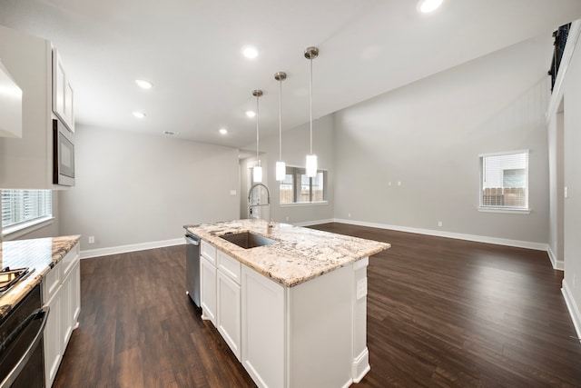 kitchen with light stone counters, recessed lighting, a sink, appliances with stainless steel finishes, and dark wood-style floors