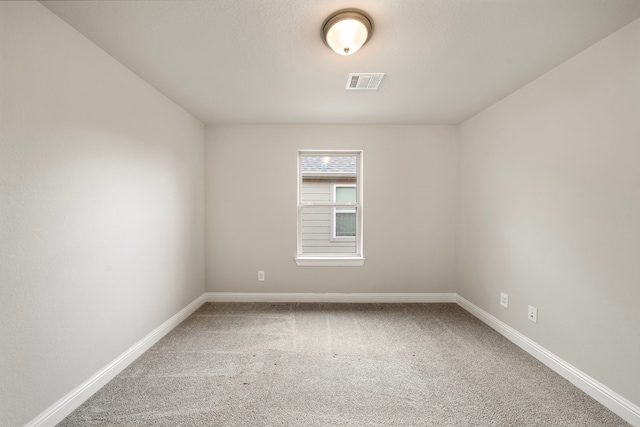 spare room with baseboards, visible vents, and carpet flooring