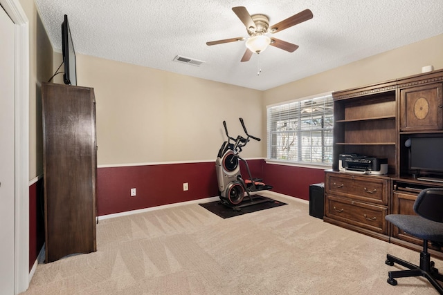 office area featuring visible vents, a ceiling fan, light carpet, a textured ceiling, and baseboards