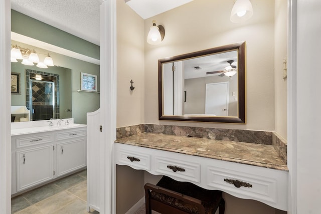 bathroom featuring a textured ceiling, ceiling fan, tile patterned flooring, vanity, and a stall shower