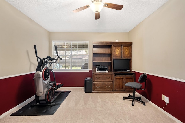 home office featuring a textured ceiling, carpet floors, a ceiling fan, and baseboards