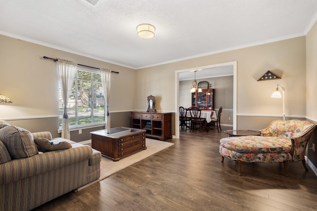 living area featuring crown molding, a textured ceiling, baseboards, and wood finished floors