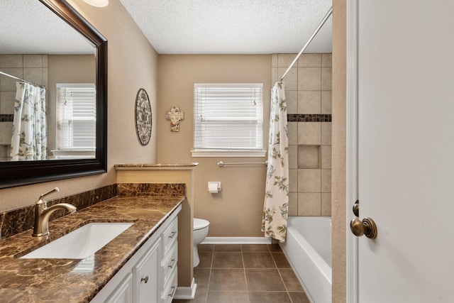 bathroom with a textured ceiling, vanity, tile patterned flooring, and toilet