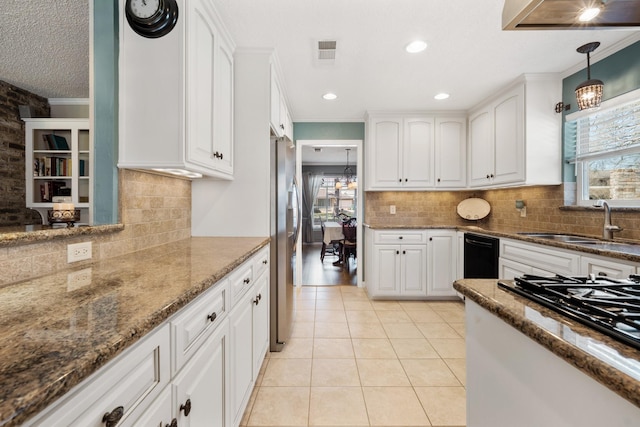 kitchen with light tile patterned flooring, visible vents, white cabinets, stainless steel fridge, and crown molding