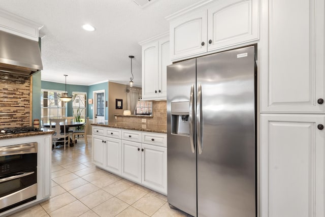 kitchen with gas cooktop, wall chimney exhaust hood, backsplash, and stainless steel fridge with ice dispenser