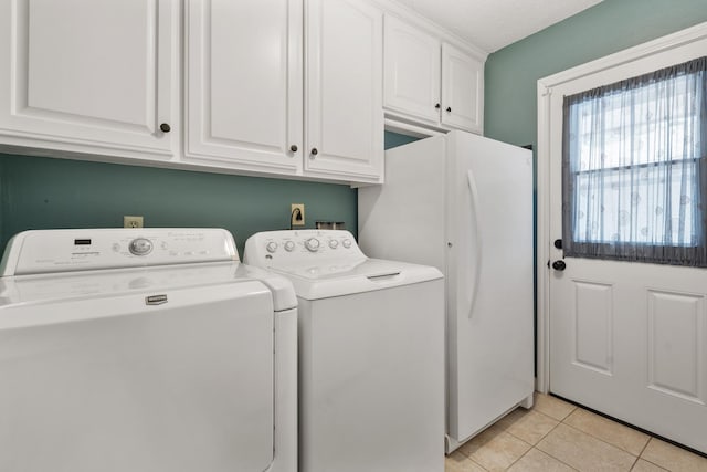 clothes washing area featuring cabinet space, washing machine and dryer, light tile patterned floors, and a textured ceiling