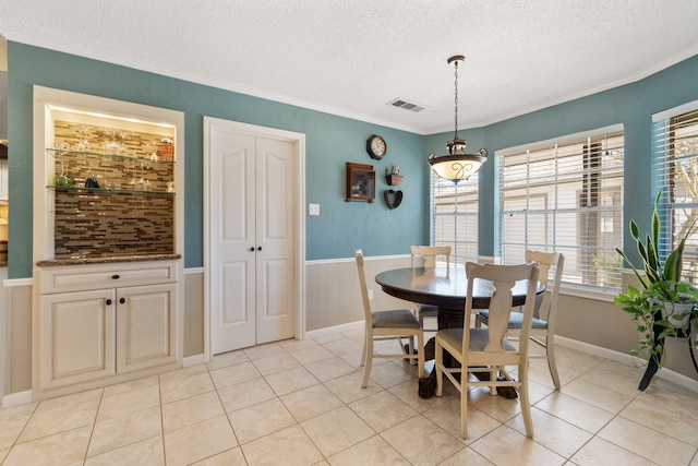 dining space with a textured ceiling, plenty of natural light, and visible vents