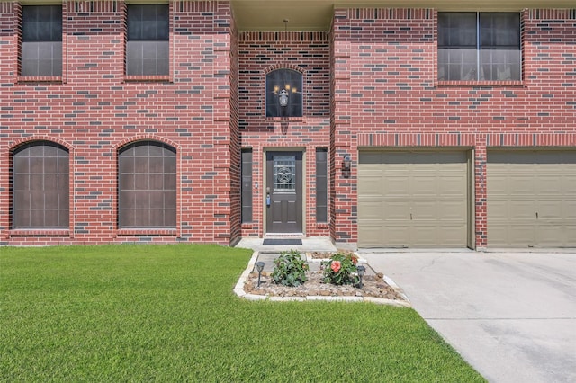 view of exterior entry with a garage, a yard, brick siding, and driveway