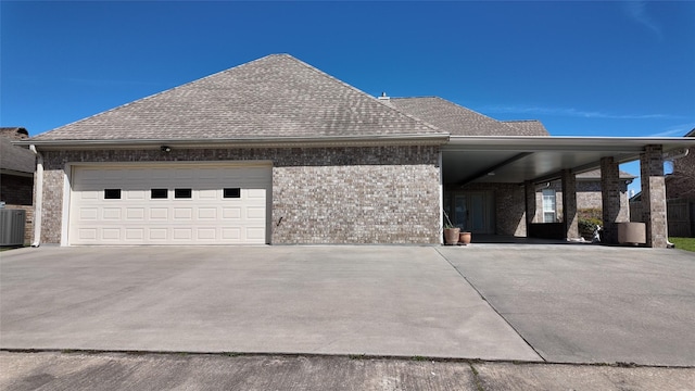 view of front facade with a garage, a shingled roof, concrete driveway, and brick siding