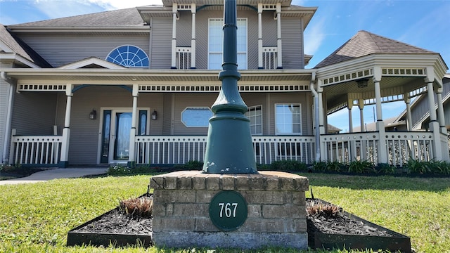 view of front of house with a front yard and covered porch