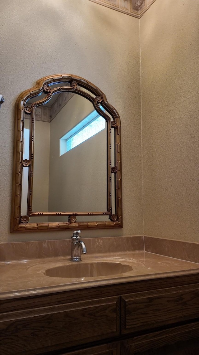 bathroom featuring a textured wall and vanity