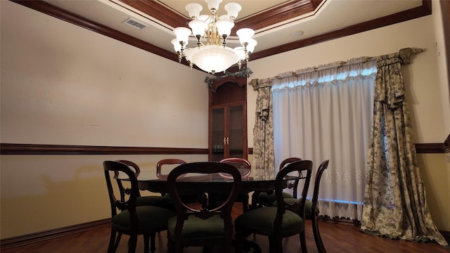 dining space with a tray ceiling, ornamental molding, visible vents, and an inviting chandelier