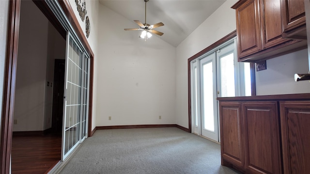 interior space featuring lofted ceiling, ceiling fan, light carpet, and baseboards