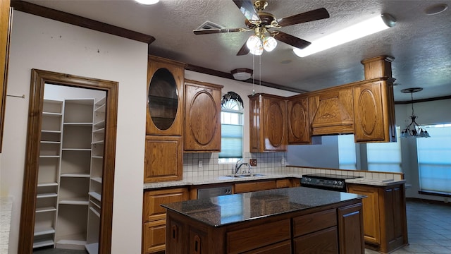 kitchen with a center island, a peninsula, a sink, a textured ceiling, and backsplash