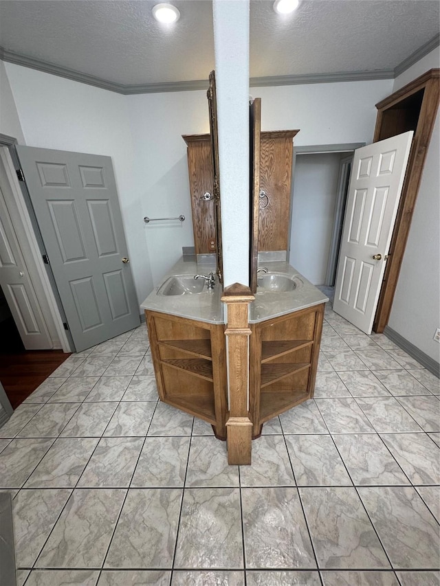 interior space featuring a textured ceiling, crown molding, and vanity