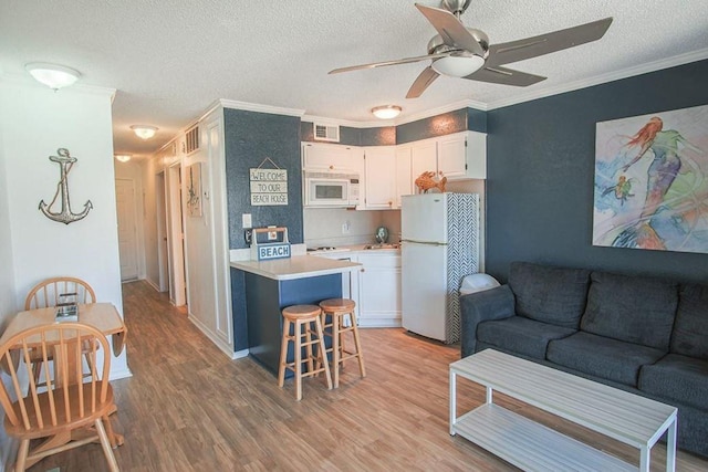 kitchen with white appliances, visible vents, open floor plan, and light countertops