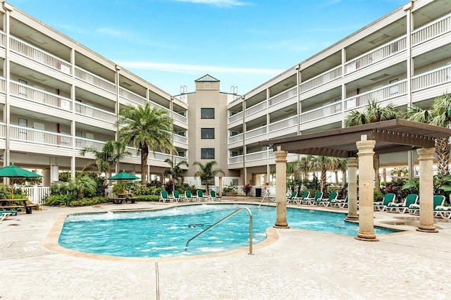 community pool with a patio area and a pergola