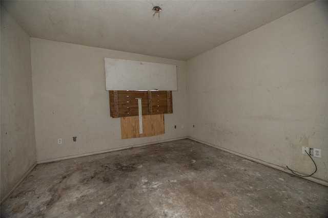 unfurnished room with unfinished concrete flooring