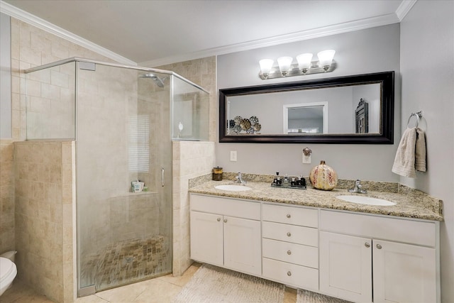 bathroom with double vanity, a stall shower, ornamental molding, and a sink