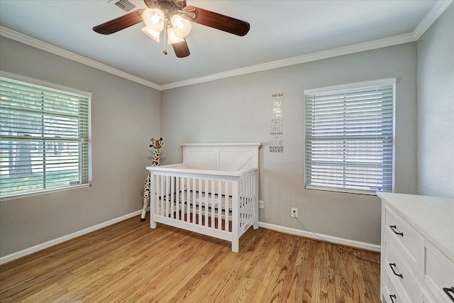 bedroom with crown molding, light wood-style flooring, and baseboards