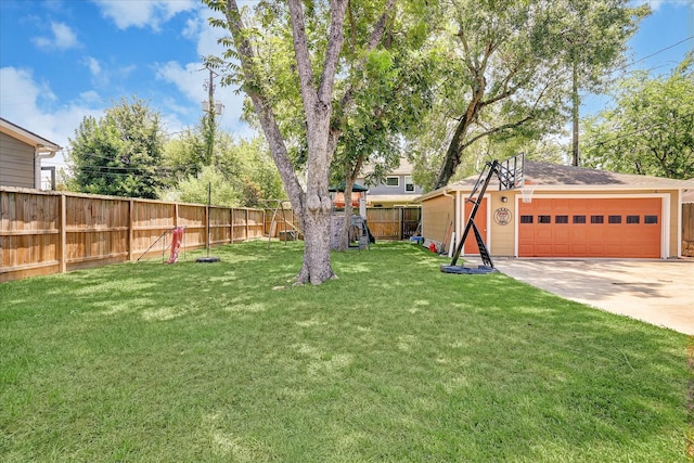 view of yard featuring a garage, fence private yard, and an outdoor structure