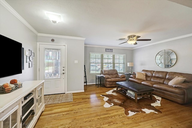 living room with ornamental molding, baseboards, light wood finished floors, and a ceiling fan