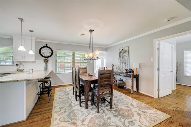 dining space featuring visible vents, crown molding, and light wood-style flooring