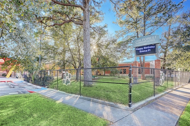 view of property's community with a yard and fence