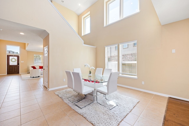 dining room featuring light tile patterned flooring, plenty of natural light, and baseboards