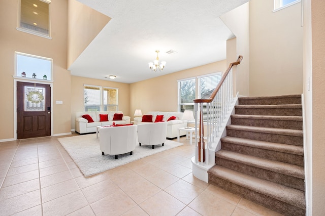 entryway with a healthy amount of sunlight, light tile patterned floors, and stairs