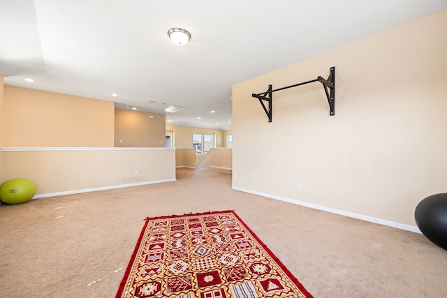 workout area featuring recessed lighting, baseboards, and light colored carpet