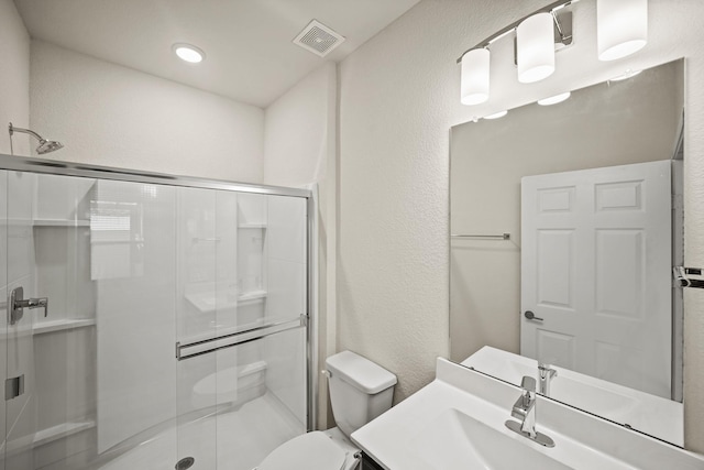 bathroom with toilet, a stall shower, and visible vents