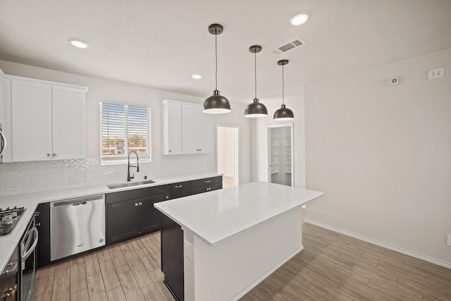 kitchen featuring a sink, visible vents, white cabinets, appliances with stainless steel finishes, and backsplash