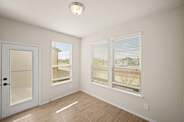 empty room with light wood-type flooring and baseboards