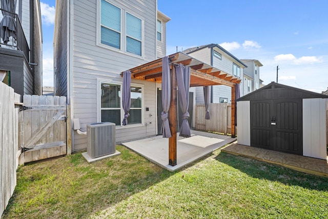 rear view of property with a storage shed, a patio area, central AC, fence, and an outdoor structure