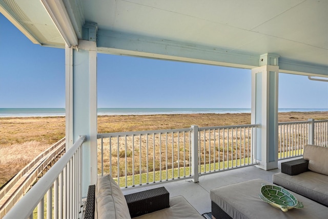 balcony with a water view and a view of the beach