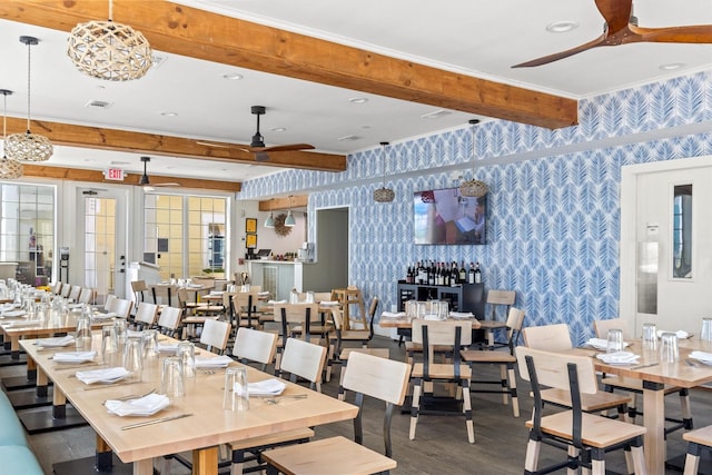 dining area with wallpapered walls, visible vents, ceiling fan, beamed ceiling, and wood finished floors