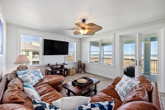 living area with ceiling fan, baseboards, and wood finished floors