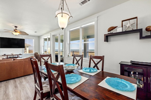 dining room featuring visible vents, ceiling fan, and wood finished floors