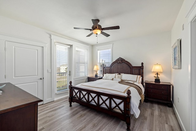 bedroom with a ceiling fan, access to outside, multiple windows, and light wood finished floors