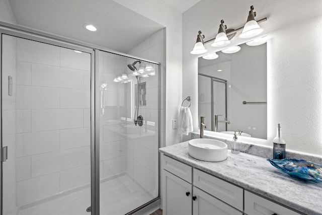 bathroom featuring a shower stall and vanity