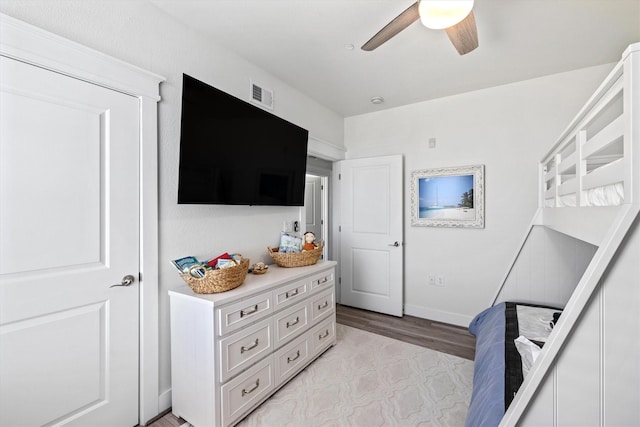 bedroom featuring baseboards, visible vents, ceiling fan, and light wood finished floors