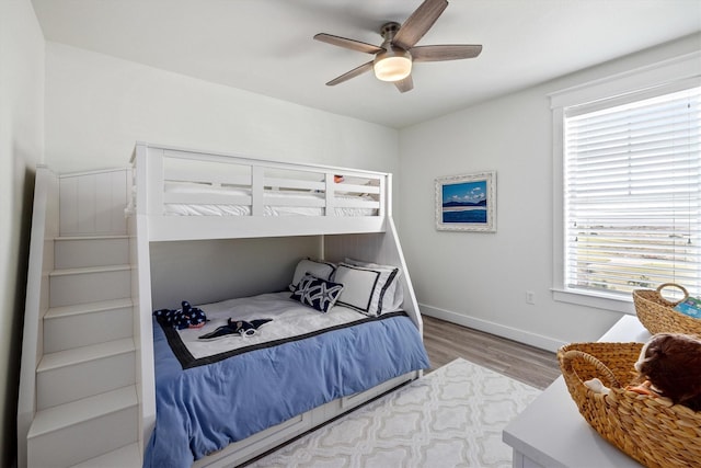 bedroom featuring ceiling fan, baseboards, and wood finished floors