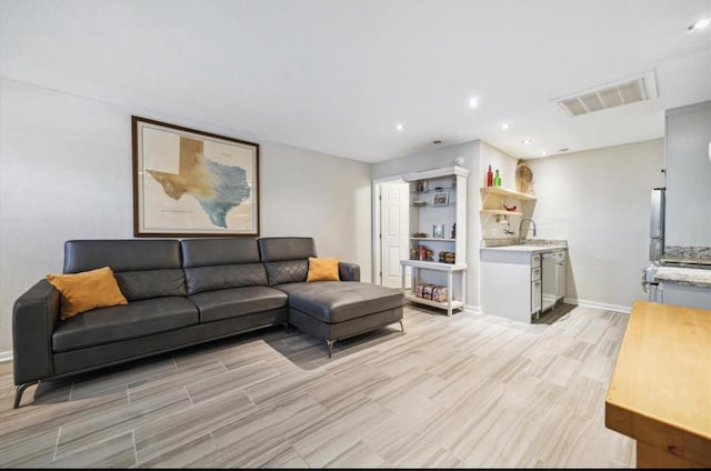 living area featuring light wood finished floors, recessed lighting, visible vents, and baseboards