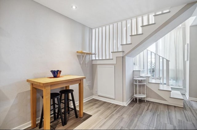 stairway with recessed lighting, wood finished floors, and baseboards