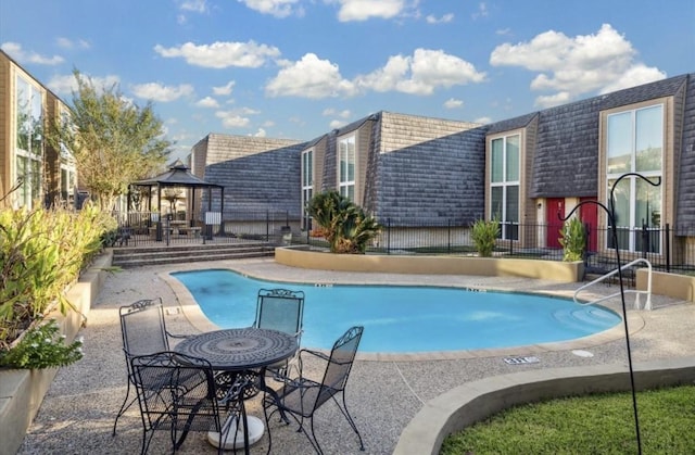 community pool with a patio and a gazebo