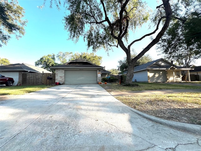 view of front of property featuring a garage, concrete driveway, and fence