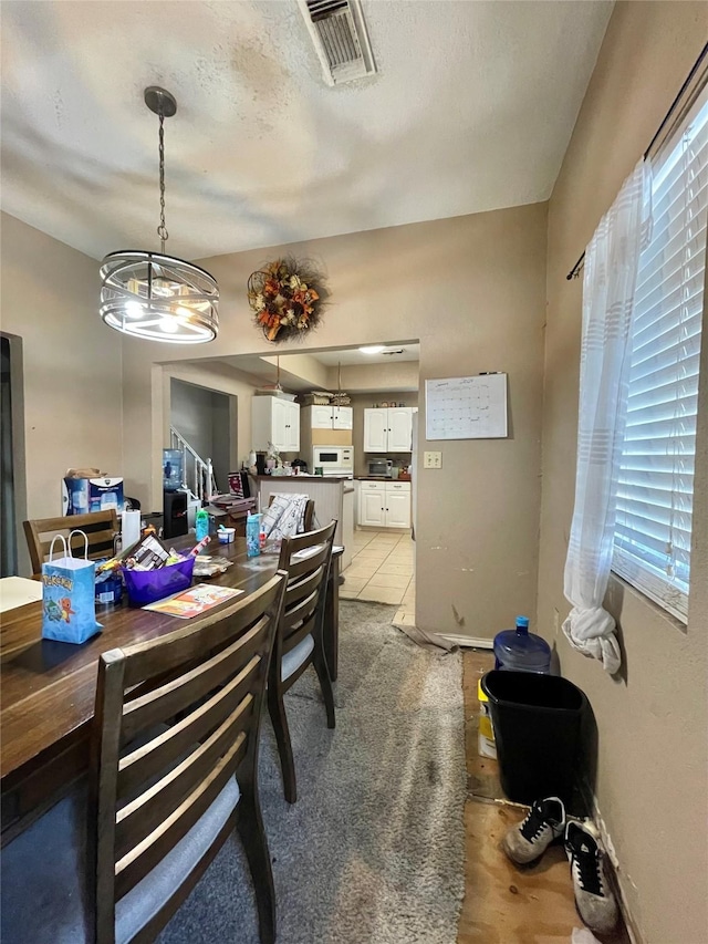 dining room featuring visible vents, a textured ceiling, and baseboards