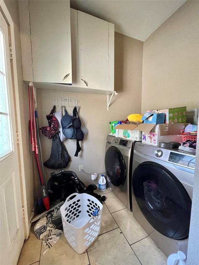 laundry area with cabinet space, light tile patterned flooring, and independent washer and dryer